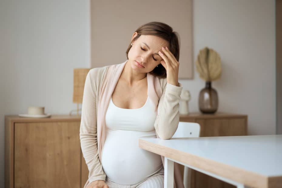 Quando começam os enjoos na gravidez. Mulher grávida sentada sentindo enjoo.
