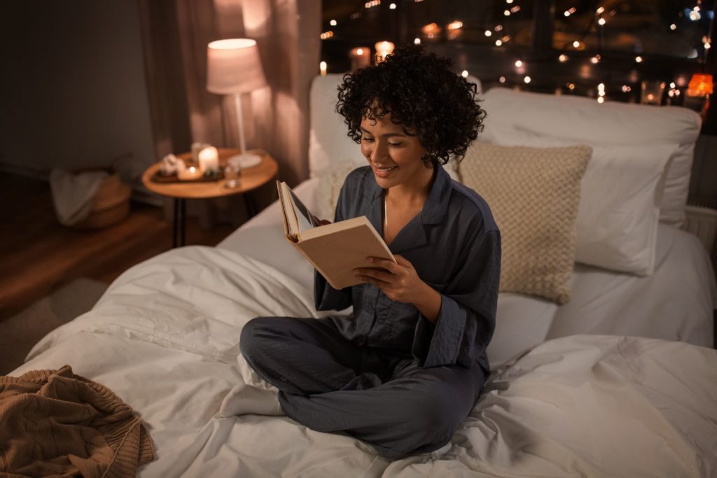 mulher lendo sentada na cama