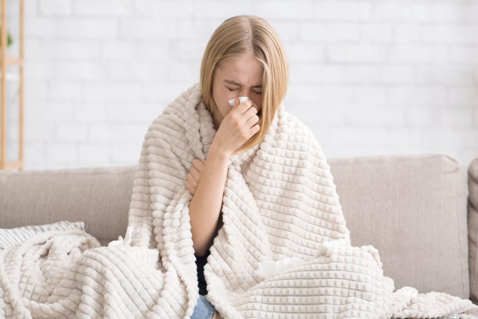 mulher jovem loira com sintomas de gripe