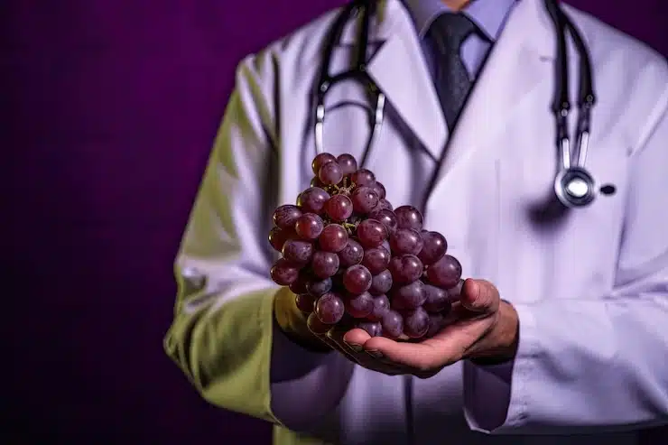 médico segurando uvas o componente do resveratrol melhor marca